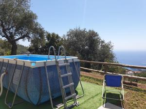 Un columpio y una escalera junto a una piscina. en Casa Valeria in the countryside, en SantʼAgata sui Due Golfi