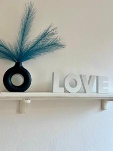 a black vase sitting on a shelf with the word love at Mary's Home Cogoleto in Cogoleto