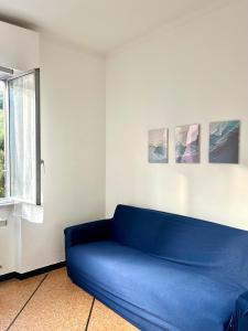 a blue couch in a room with a window at Mary's Home Cogoleto in Cogoleto