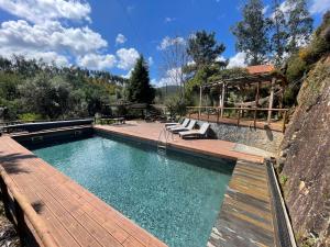 a large swimming pool with a wooden deck at Quinta dos Millagres Studio Apartment in Friumes