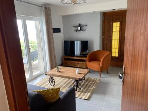 a living room with a table and a chair and a television at Les Brises in Saint-Gingolph