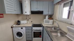 een keuken met een wasmachine en een wastafel bij Alamar T1 Altura Beach in Altura +7 foto's