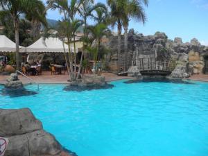 a swimming pool in a resort with a waterfall at Comodo Apartamento con Terraza y Vistas al Mar in Los Realejos +17 photos