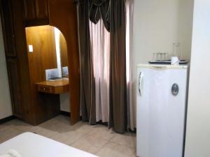 a kitchen with a white refrigerator and a wooden door at Tubod Flowing Water Resort in Minglanilla