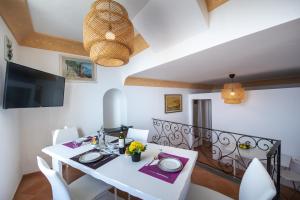 a dining room with a white table and white chairs at Villa Cimino - for walking lovers! in Praiano