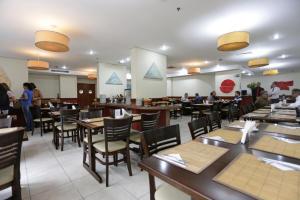 - un restaurant avec des tables, des chaises et des tables dans l'établissement Paulista Classic Flat Bela Cintra 672 São Paulo, à São Paulo