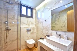 a bathroom with a shower and a sink and a toilet at Oras Corfu Contessa in Áno Korakiána +17 photos