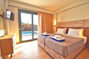 a hotel room with a bed with two towels on it at Oras Corfu Contessa in Áno Korakiána