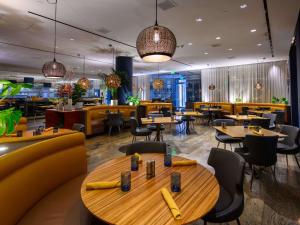 a restaurant with tables and chairs and a cafeteria at Hotel Sofitel Los Angeles at Beverly Hills in Los Angeles