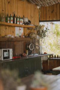 ダラットにあるMái Lá Homestay & Herbal Spaの木製の壁のキッチン、鍋とフライパン付きのカウンター +191枚の写真