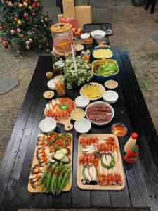 ダラットにあるMái Lá Homestay & Herbal Spaのさまざまな種類の食べ物が並んだテーブル