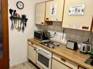 a kitchen with a counter with a stove and a microwave at Deine Pension, Double Room P1, 1-2 beds, 10qm, Check-in 4PM - 5AM in Creglingen