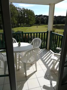 a patio with a table and chairs and a golf course at Flat 4 person on golf view in Talmont