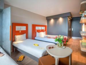 a hotel room with two beds and a table at ibis budget Nice Californie Lenval in Nice