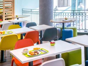 a cafeteria with tables and chairs with food on them at ibis budget Nice Californie Lenval in Nice