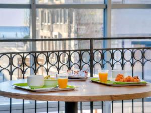 a table with two plates of food and orange juice at ibis budget Nice Californie Lenval in Nice