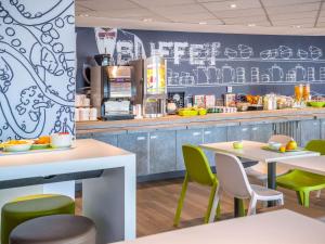 a restaurant with tables and chairs and a kitchen at ibis budget Nice Californie Lenval in Nice
