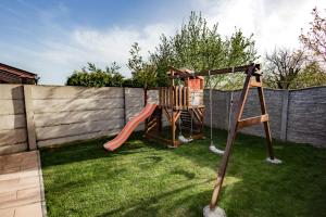 a playground with a slide in a backyard at Scarlett Pension & Restaurant in Veľký Meder