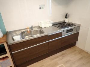 eine Küche mit Spüle und Herd in der Unterkunft 家族の笑顔 希望ヶ丘ビーチまで徒歩5分でのんびり家族ステイ Coral Onnason in Onna