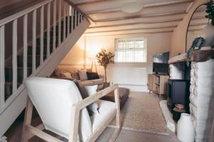a living room with a white couch and stairs at North Lakes - The Byre Holiday Cottage in Penrith
