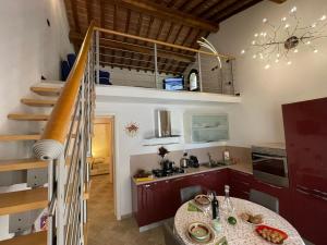 a kitchen with a table and a spiral staircase at Casa Rosmarino, grill, Wi-Fi by ToscanaTour in Riparbella