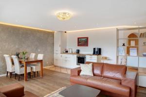 Una sala de estar y una cocina con un sofá y una mesa. en Apartment zum Wohlfühlen, en Garmisch-Partenkirchen