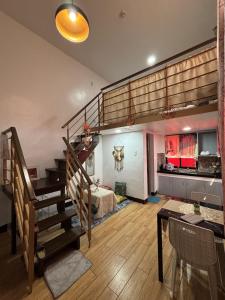 a living room with a staircase and a bedroom at Kazoku Hostel in Olongapo