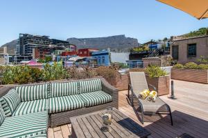 a patio with a couch and chairs on a deck at See Table Mountain from a Historic Home in Cape Town