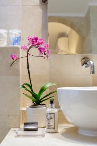 a bathroom with a sink and a flower on a counter at See Table Mountain from a Historic Home in Cape Town