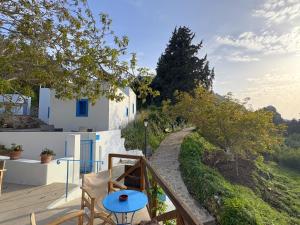 a balcony of a house with a blue table at The Water Mill Cottage in Lagoúdi Zía