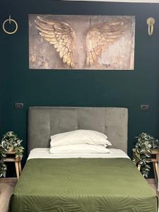 a bedroom with a bed with an angel painting on the wall at Lungotevere Testaccio 6 Roma - Apartments in Rome