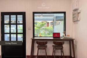 a table with two chairs and a laptop on it at CHANN Guesthouse in Betong