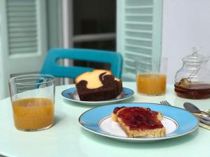 a table with two plates of food and two glasses of orange juice at Central -I- Apartment in Athens