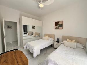 a bedroom with two beds and a wooden table at Casa Fe in Morro del Jable