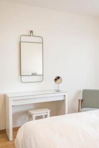 a bedroom with a white desk and a mirror at Modern appt opposite theatre, 7 min walk to Messe in Klein-Basel +14 photos