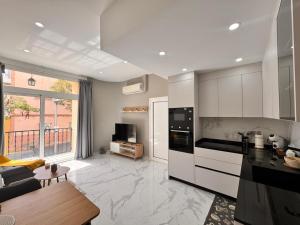 a kitchen with white cabinets and a living room at Casa Fe in Morro del Jable +27 photos