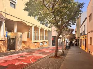 a street with a tree and a mural on the sidewalk at Casa Fe in Morro del Jable