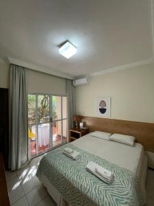 a bedroom with a bed with two towels on it at Hotel Charme Fonte do Boi in Salvador