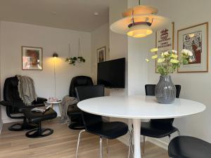 a room with a table and chairs and a vase of flowers at Pakhuset, DownTownSkagen in Skagen