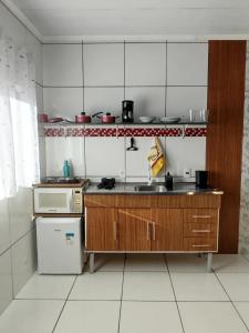 a small kitchen with a sink and a refrigerator at AH Amabille House in Serra Negra