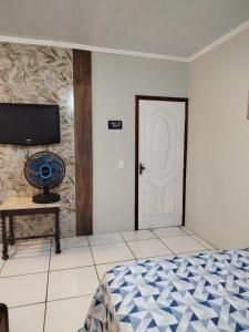1 dormitorio con cama y puerta blanca en AH Amabille House, en Serra Negra