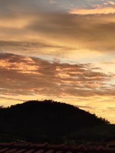 a sunset with a mountain in the background at AH Amabille House in Serra Negra
