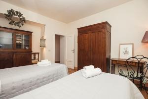 a bedroom with two beds and a wooden cabinet at Giardino Segreto in Cetona
