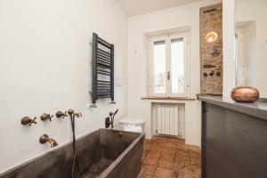 a bathroom with a bath tub and a toilet at Giardino Segreto in Cetona +53 photos