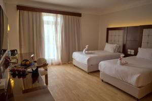 a hotel room with two beds and a couch at Diamond Beach by Pearl Resorts in Quseir