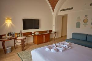 a hotel room with a bed and a television at Diamond Beach by Pearl Resorts in Quseir