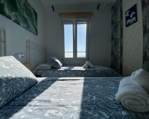 a bedroom with two beds and a window at Respirando salitre apartamento en Lastres in Lastres