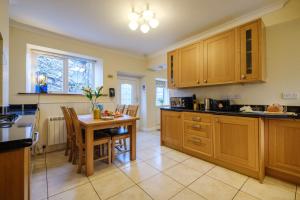 a kitchen with wooden cabinets and a table and chairs at Victory Cottage in Ambleside