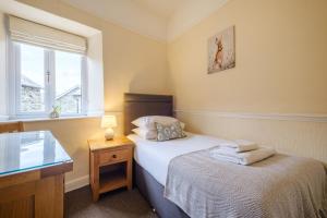 a small bedroom with a bed and a window at Victory Cottage in Ambleside