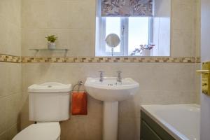 a bathroom with a white toilet and a sink at Victory Cottage in Ambleside +20 photos